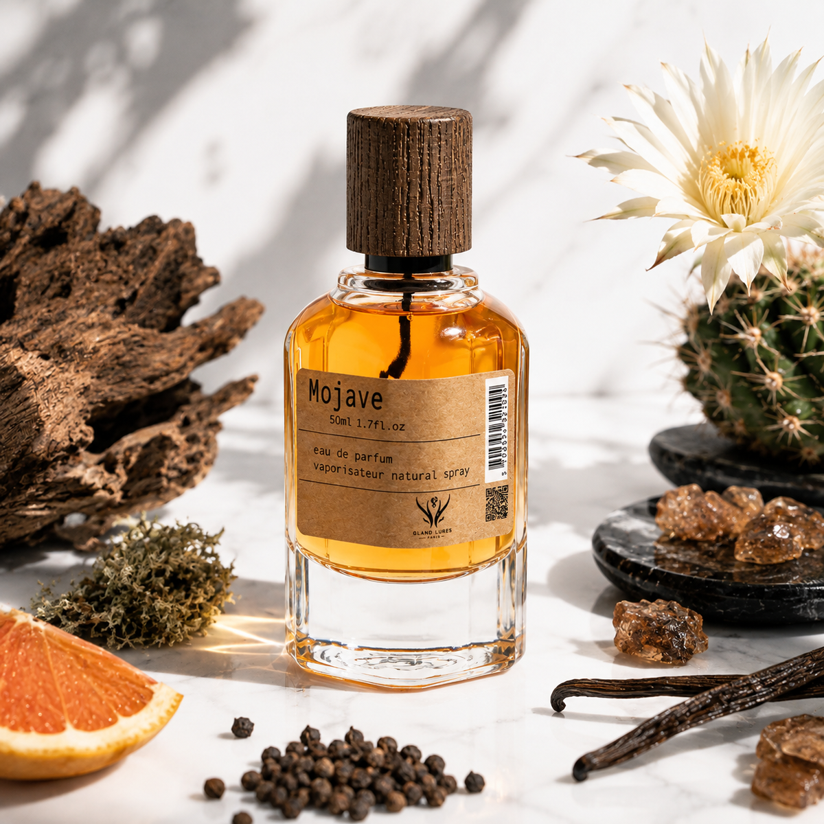 A bottle of Mojave Eau de Parfum by Wild Rose Scents, featuring amber liquid and a dark wood cap, styled with desert and citrus ingredients on a white marble surface.
