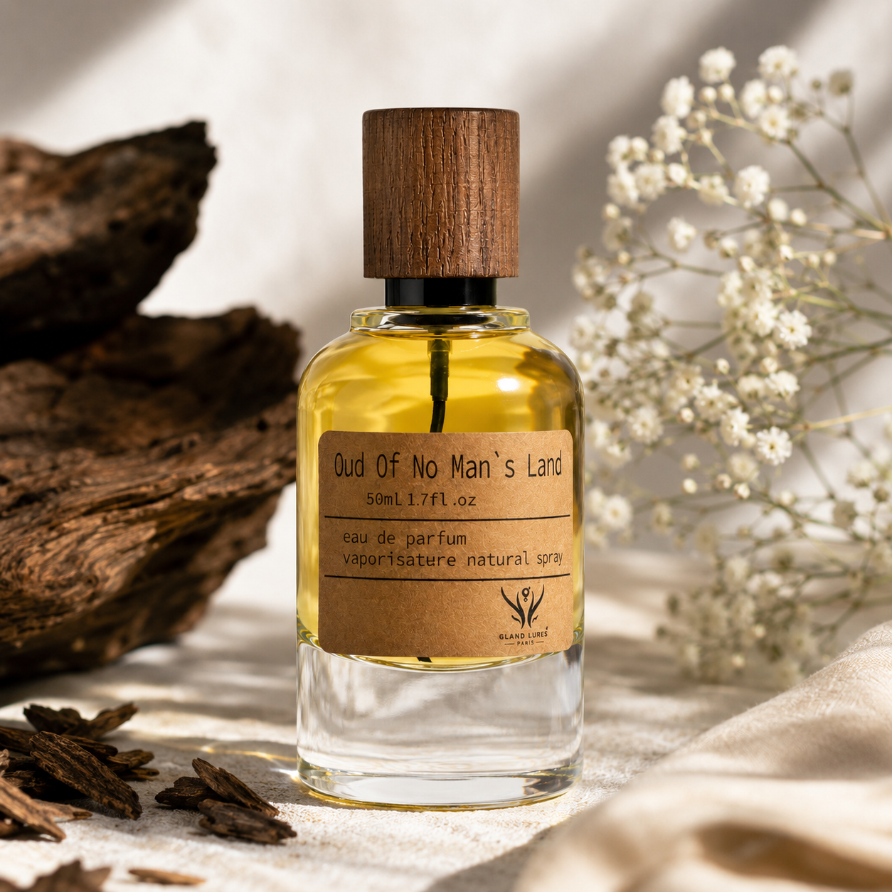 A 50ml bottle of 'Oud Of No Man's Land' natural perfume spray by Black Lotus Fragrance. The clear glass bottle is filled with golden-yellow liquid and features a dark brown wooden cap and a kraft paper label.