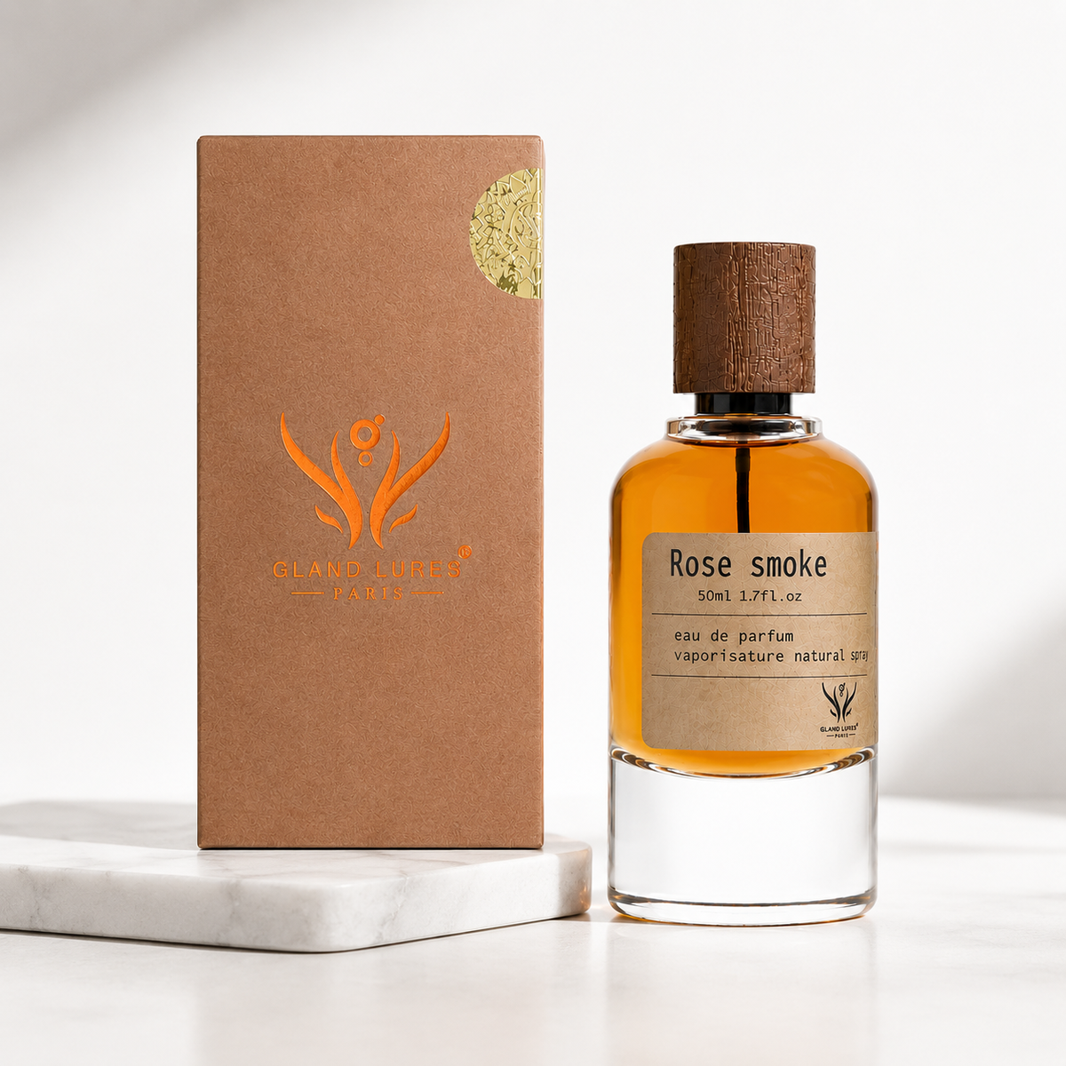 A bottle of Rose smoke eau de parfum next to its brown kraft paper packaging box, displayed on a white marble block against a clean white background.